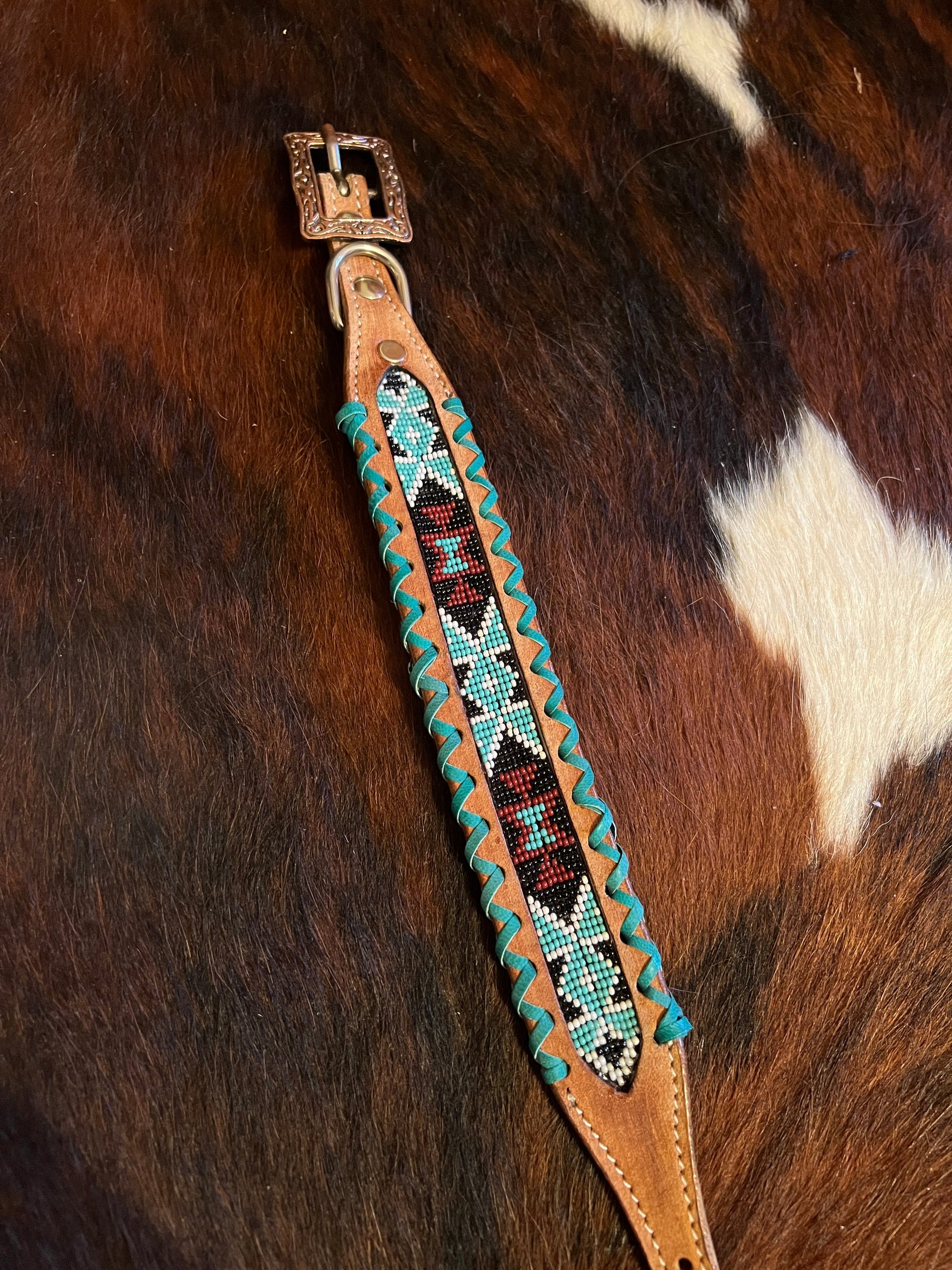 Genuine leather dog collar with teal, white, and burgundy  beaded inlay design, a rawhide wrapped edge