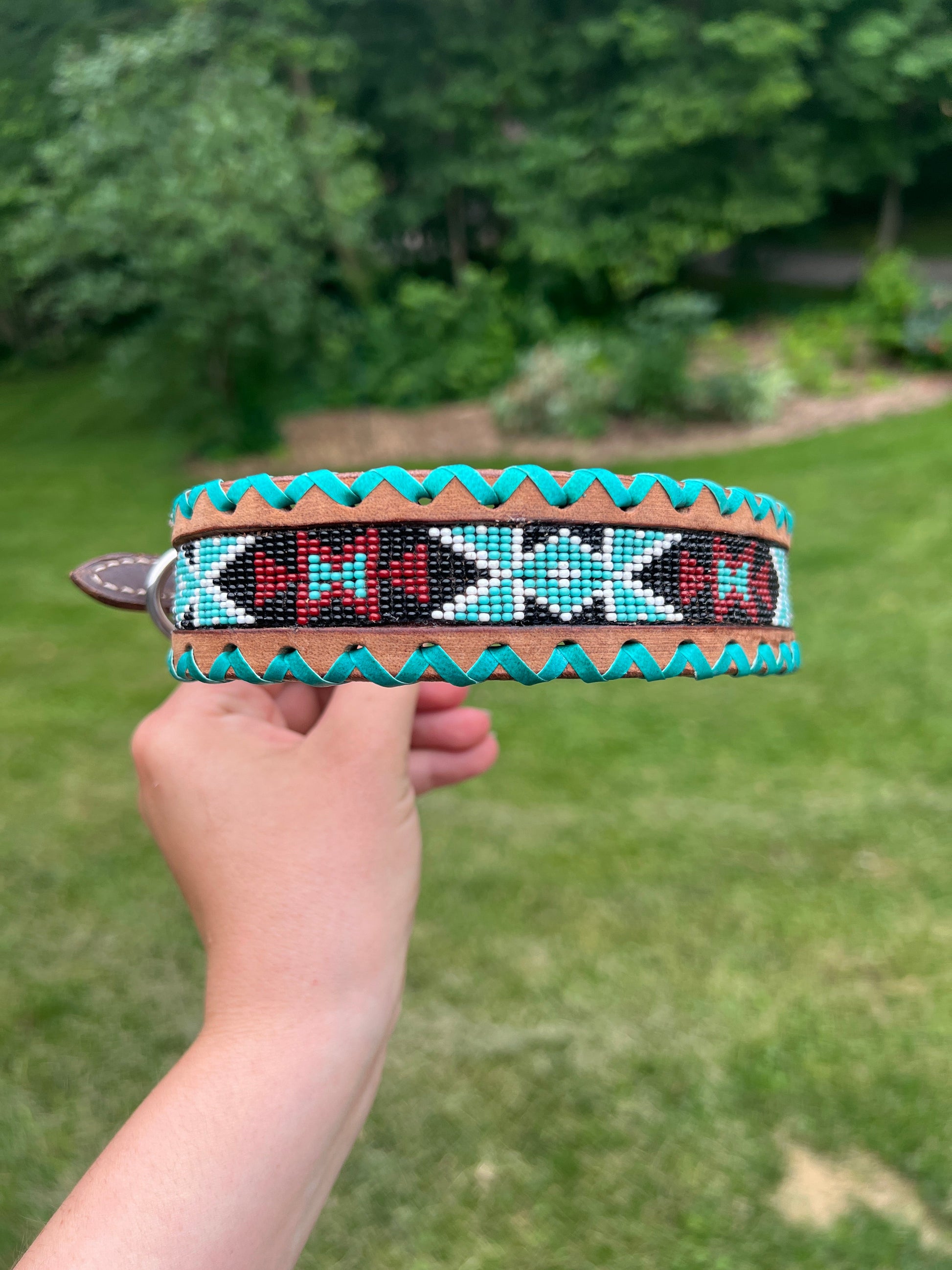 Genuine leather dog collar with teal, white, and burgundy  beaded inlay design, a rawhide wrapped edge