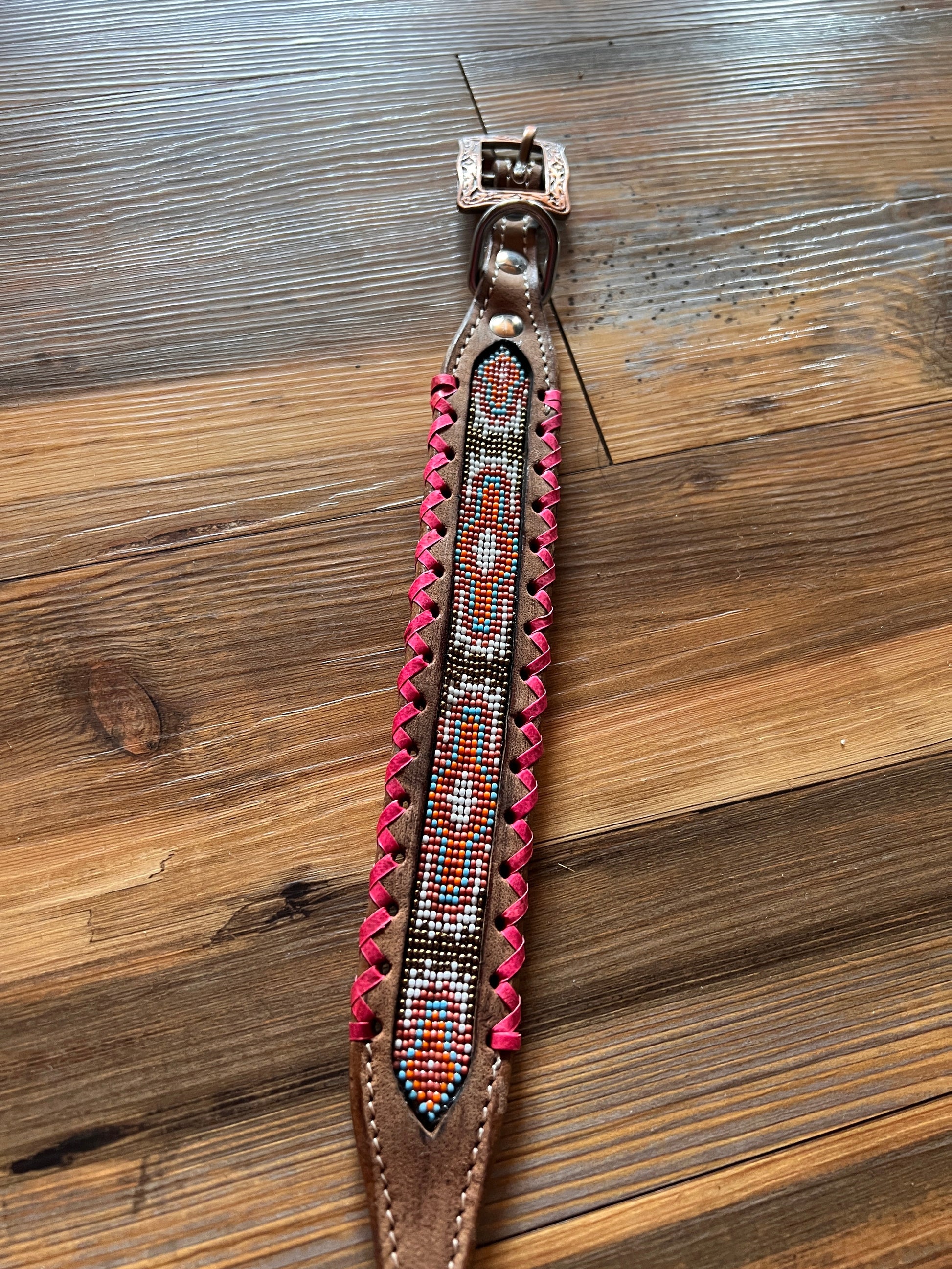 Genuine leather dog collar with pink, white, and gold navajo beaded inlay design, a rawhide wrapped edge
