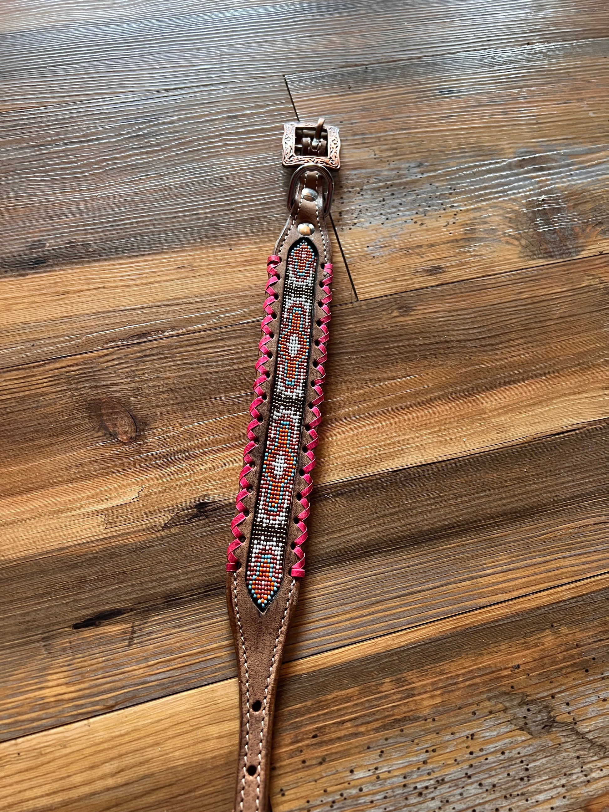 Genuine leather dog collar with pink, white, and gold navajo beaded inlay design, a rawhide wrapped edge