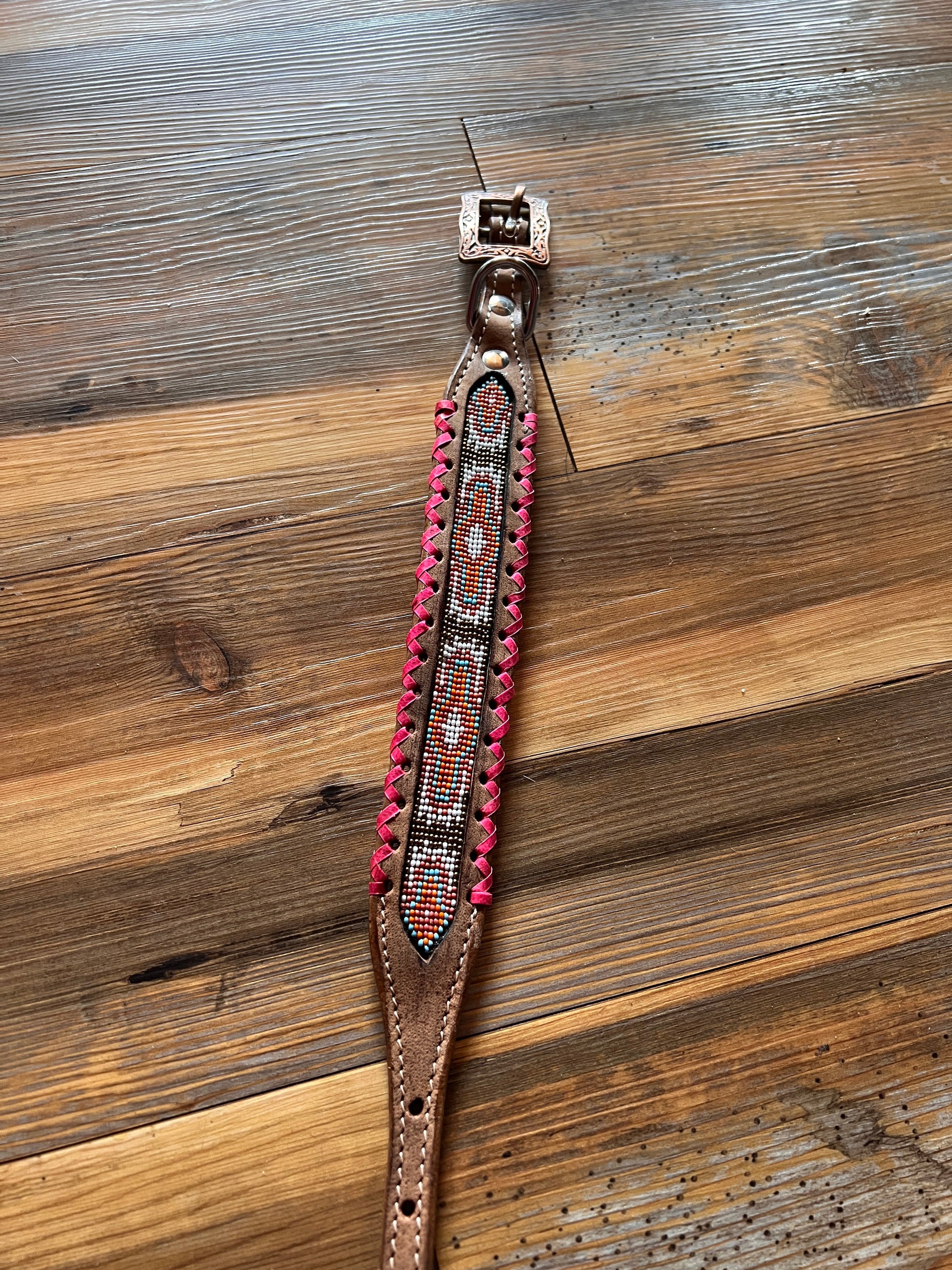 Genuine leather dog collar with pink, white, and gold navajo beaded inlay design, a rawhide wrapped edge