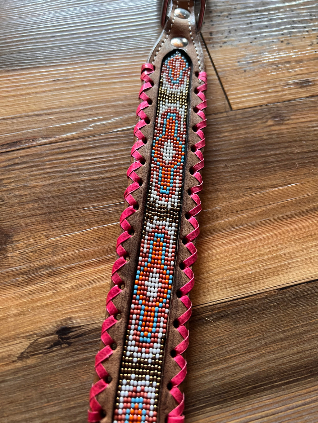 Genuine leather dog collar with pink, white, and gold navajo beaded inlay design, a rawhide wrapped edge