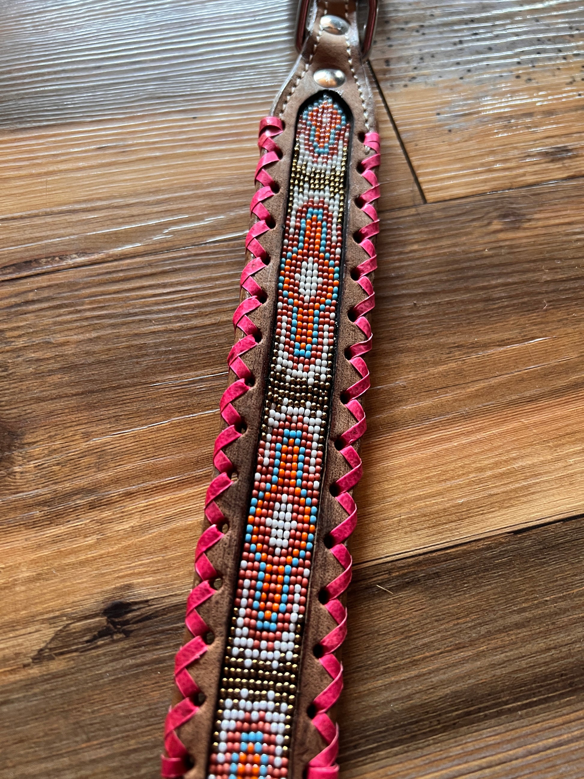 Genuine leather dog collar with pink, white, and gold navajo beaded inlay design, a rawhide wrapped edge
